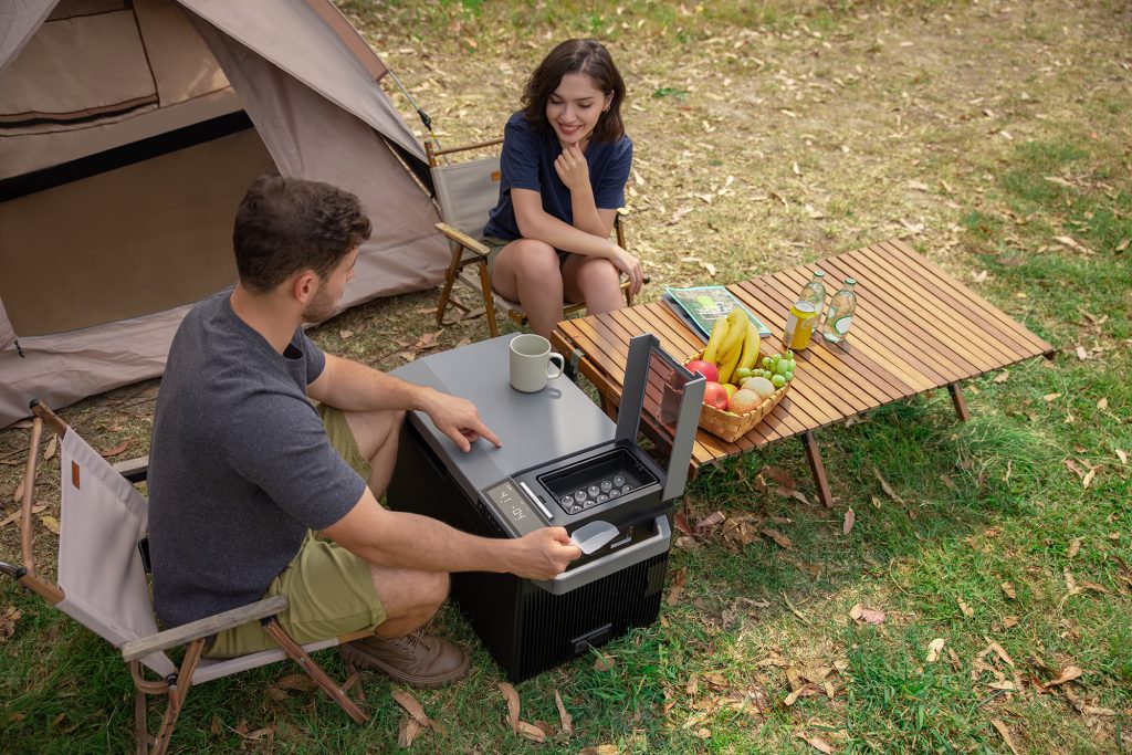 Couple enjoys the EcoFlow Glacier portable refrigerator keeping food cold and providing ice while camping.